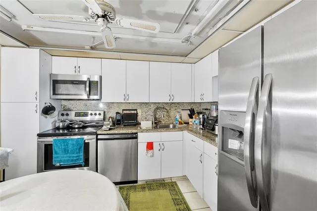 a kitchen with stainless steel appliances granite countertop a stove a refrigerator and a microwave