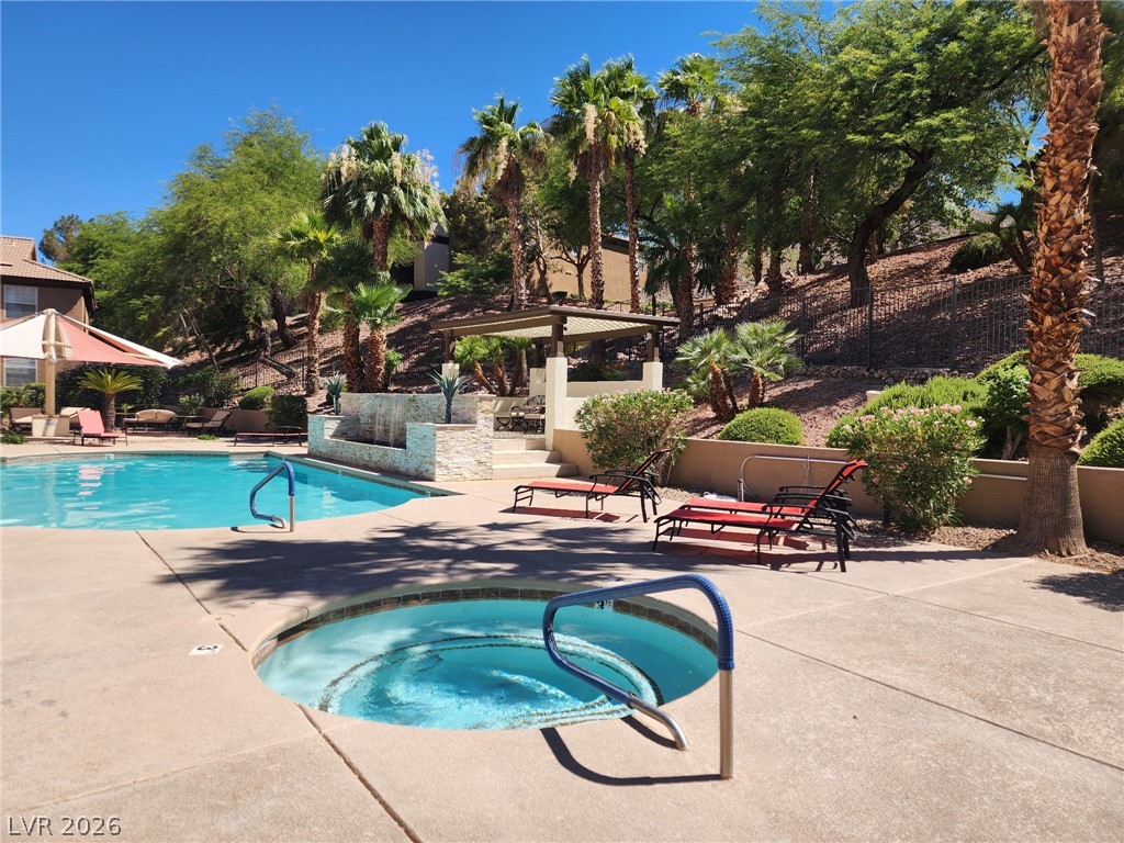 231 West Horizon Ridge Parkway, Unit 1127 Henderson, NV 89012 - Photo 13 of 39 An inviting pool and spa area with lush landscaping awaits, perfect for leisure.