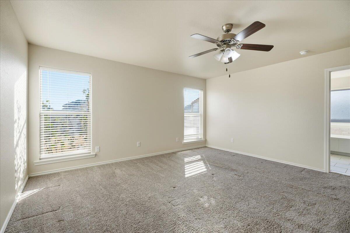 9819 Virginia Avenue Lubbock, TX 79424 - Photo 13 of 29 an empty room with windows and fan