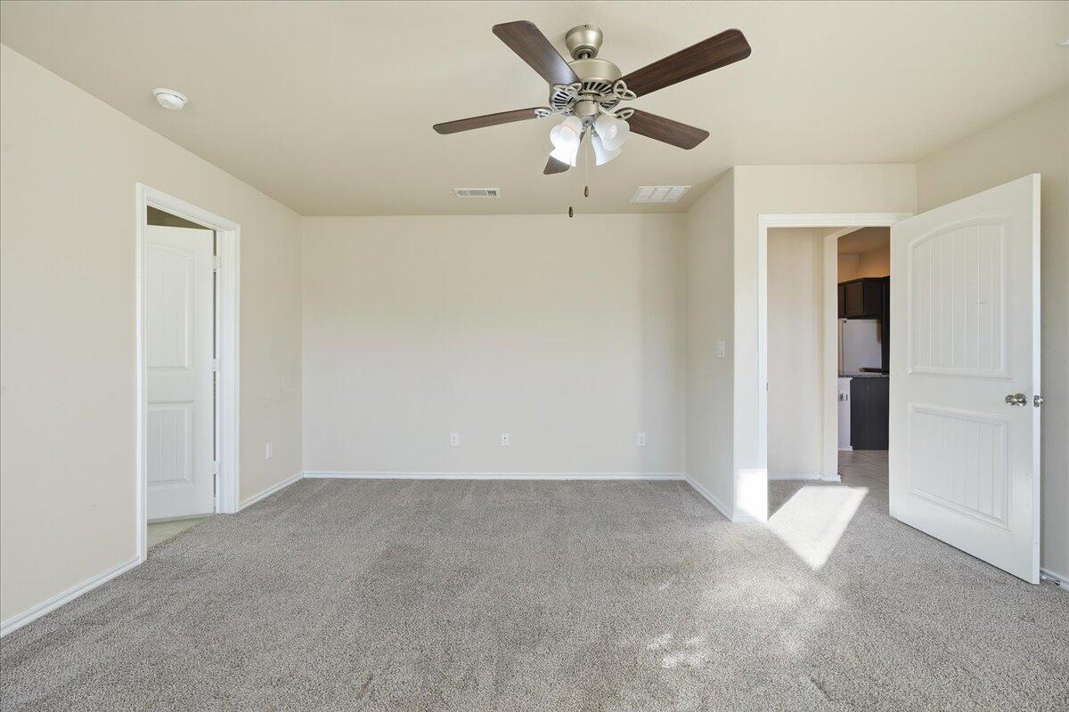 9819 Virginia Avenue Lubbock, TX 79424 - Photo 15 of 29 an empty room with a ceiling fan and carpet