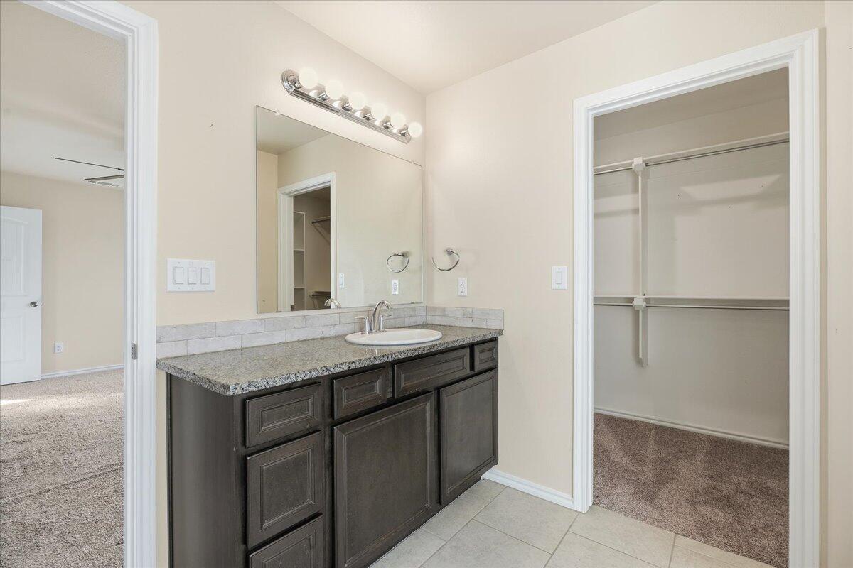 9819 Virginia Avenue Lubbock, TX 79424 - Photo 17 of 29 a bathroom with a granite countertop sink and a mirror