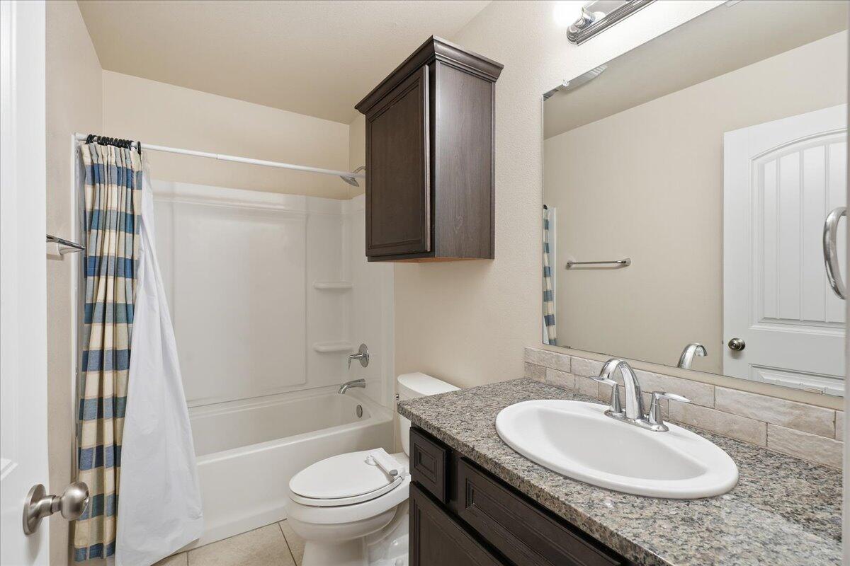 9819 Virginia Avenue Lubbock, TX 79424 - Photo 23 of 29 a bathroom with a granite countertop sink toilet and shower