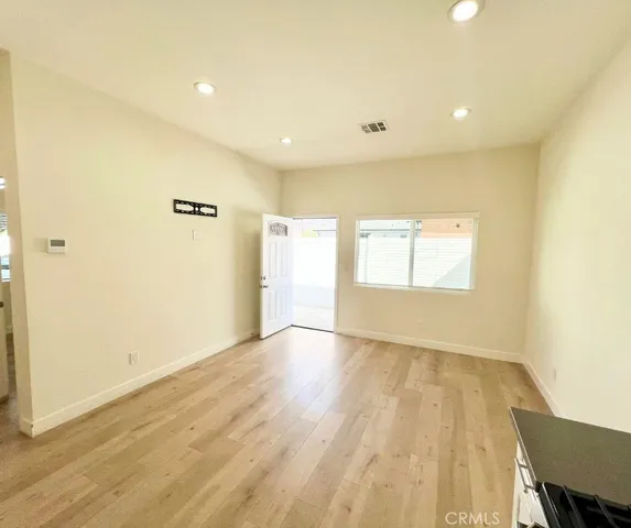 a view of an empty room with wooden floor