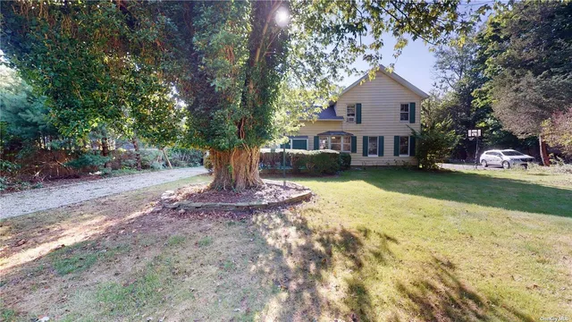 a front view of a house with a yard and trees