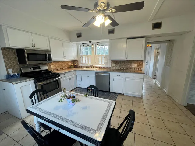 a kitchen with a sink a stove and chairs