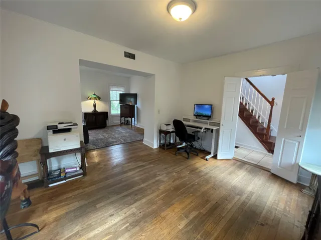 a living room with furniture and a wooden floor