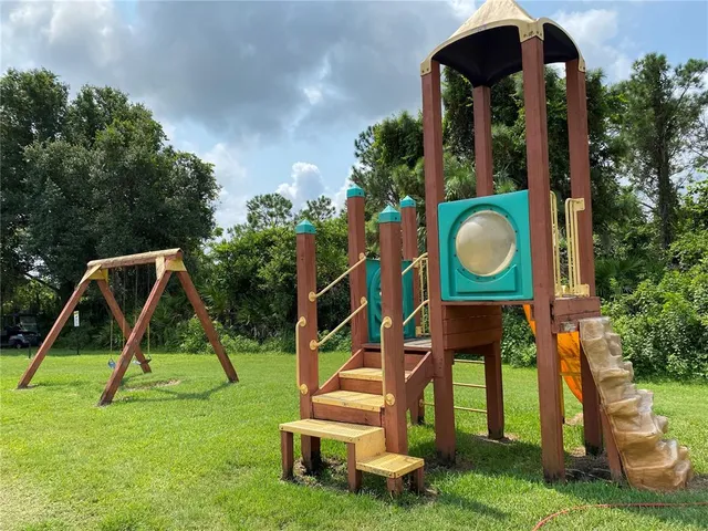 a view of an house with backyard and a slide