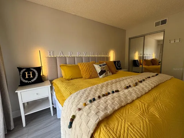 a bedroom with a bed and wooden floor