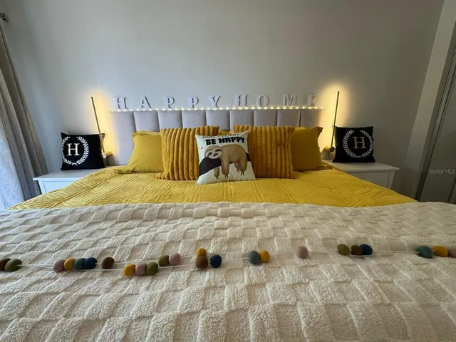 a bed sitting in a bedroom next to a lamp