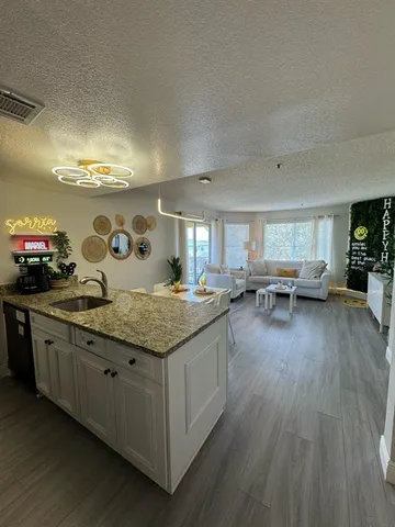 a kitchen with stainless steel appliances granite countertop a lot of counter space and wooden floor