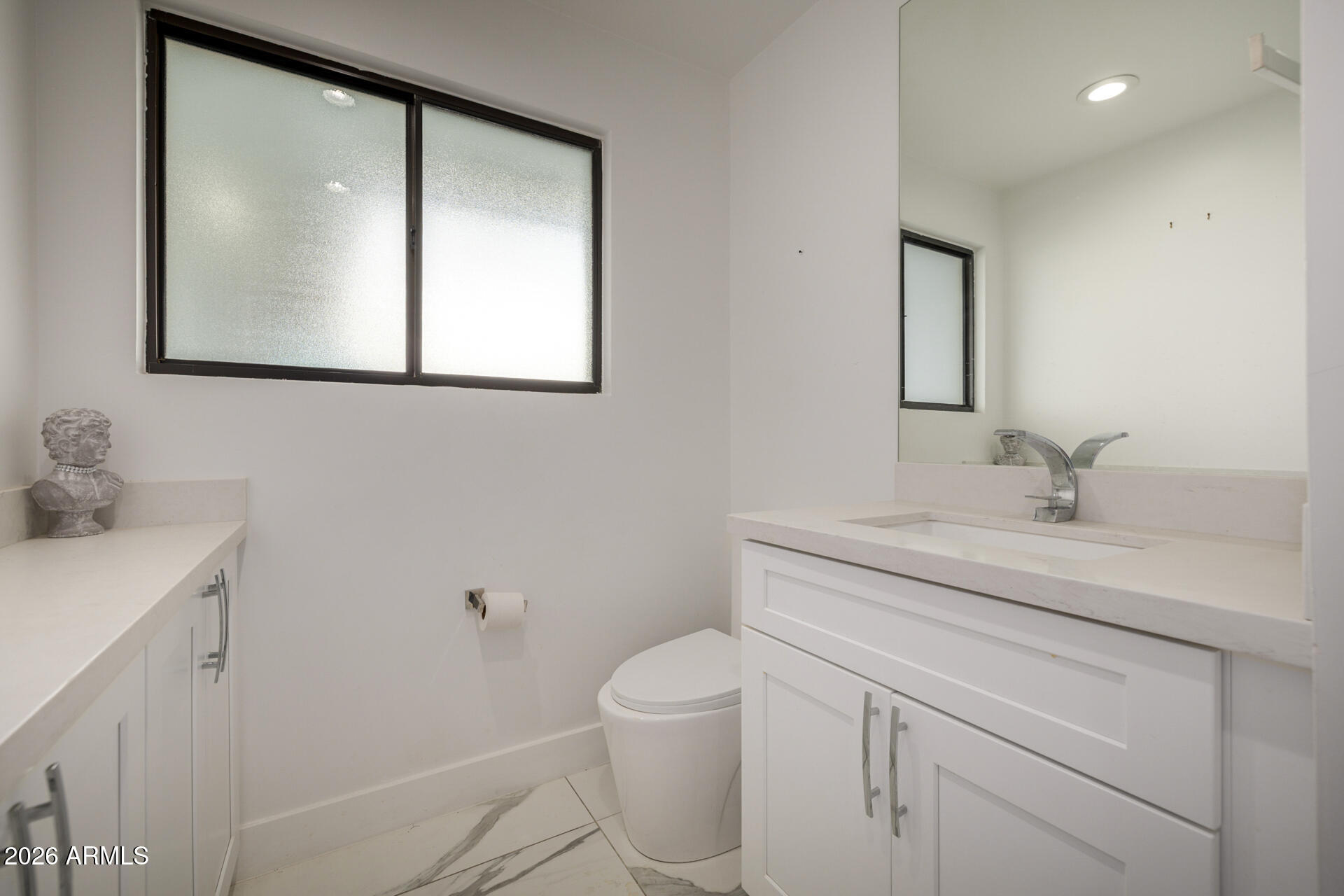 2809 East Frye Road Phoenix, AZ 85048 - Photo 26 of 47 a bathroom with a toilet sink vanity and mirror