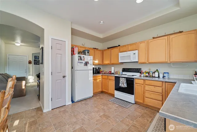 a kitchen with stainless steel appliances granite countertop a refrigerator and a stove top oven