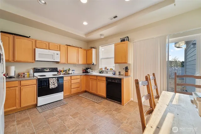 a large kitchen with stainless steel appliances granite countertop a stove a sink dishwasher and a refrigerator