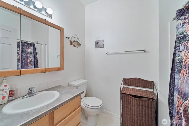 a bathroom with a granite countertop toilet sink and mirror