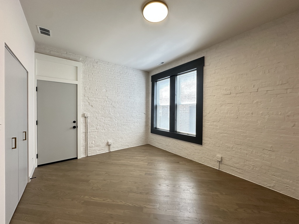 841 North Mozart Street, Unit 3F Chicago, IL 60622 - Photo 12 of 20 a view of an empty room with wooden floor and a window