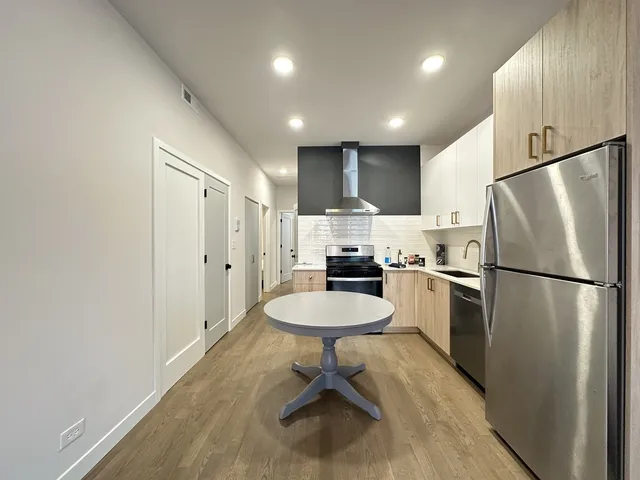 a kitchen with a refrigerator a sink and chairs