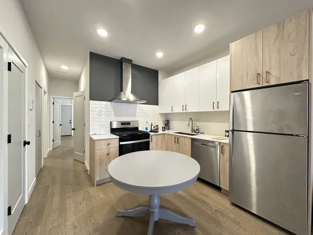 a kitchen with stainless steel appliances a refrigerator a stove a sink and a refrigerator