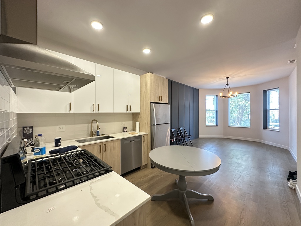 841 North Mozart Street, Unit 3F Chicago, IL 60622 - Photo 6 of 20 a kitchen with stainless steel appliances granite countertop a sink a stove a refrigerator cabinets and dining table