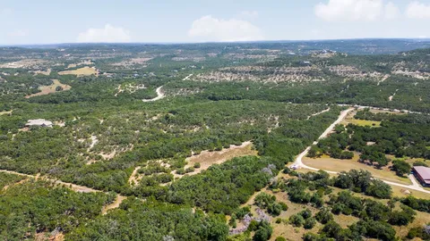 an aerial view of residential houses with outdoor space and trees