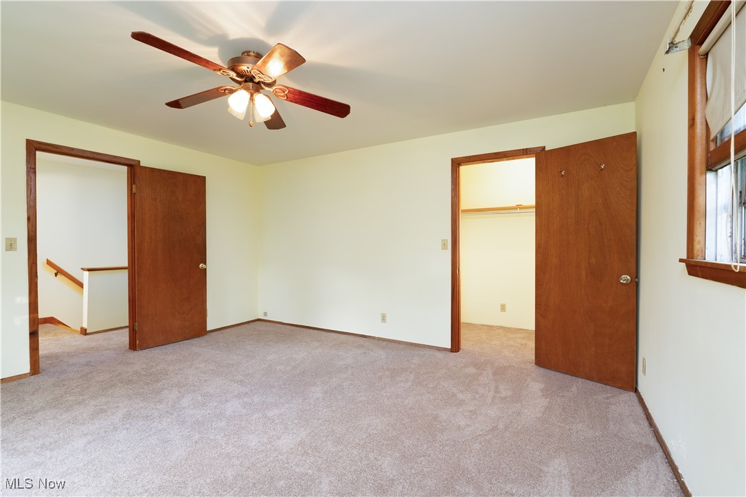 4491 Fox Road Kingsville, OH 44048 - Photo 20 of 33 Unfurnished bedroom with ceiling fan, a spacious closet, a closet, and light carpet