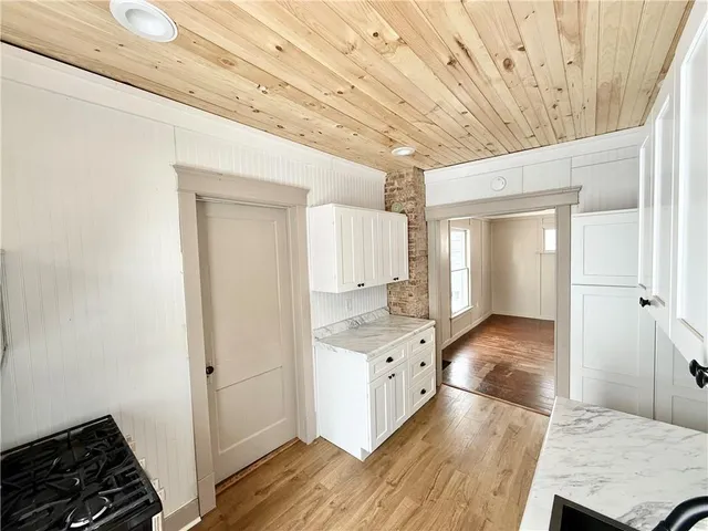 an empty room with wooden floor ceiling fan and windows