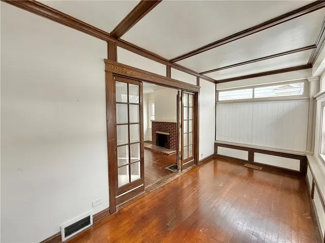 wooden floor fireplace and windows in an empty room