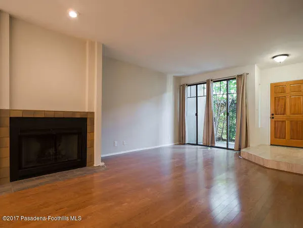 a view of an empty room with glass door and wooden floor