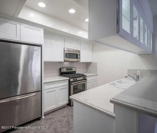 a kitchen with stainless steel appliances granite countertop a refrigerator sink and stove