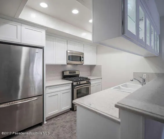 a kitchen with stainless steel appliances granite countertop a refrigerator sink and stove