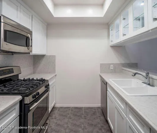 a kitchen with stainless steel appliances granite countertop a sink stove top oven and microwave