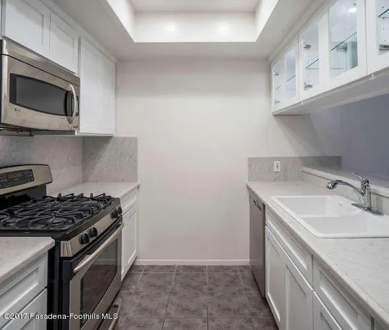 a kitchen with stainless steel appliances granite countertop a sink stove top oven and microwave