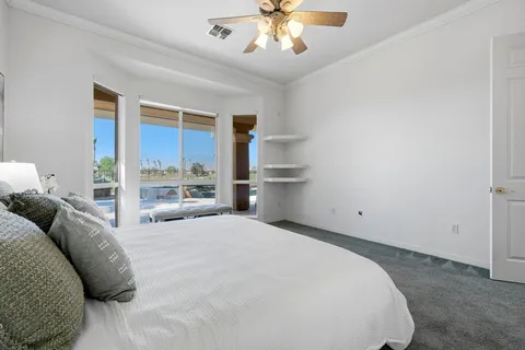 a spacious bedroom with a bed and a chandelier