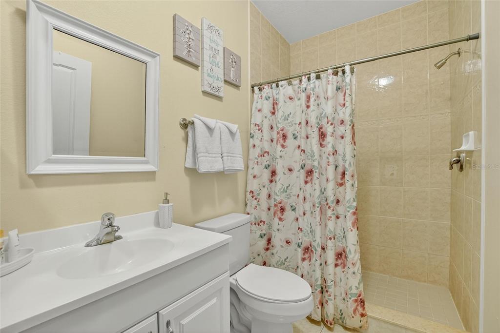 4639 Birdsong Boulevard, Unit 2 Lutz, FL 33559 - Photo 13 of 25 a bathroom with a sink toilet and shower