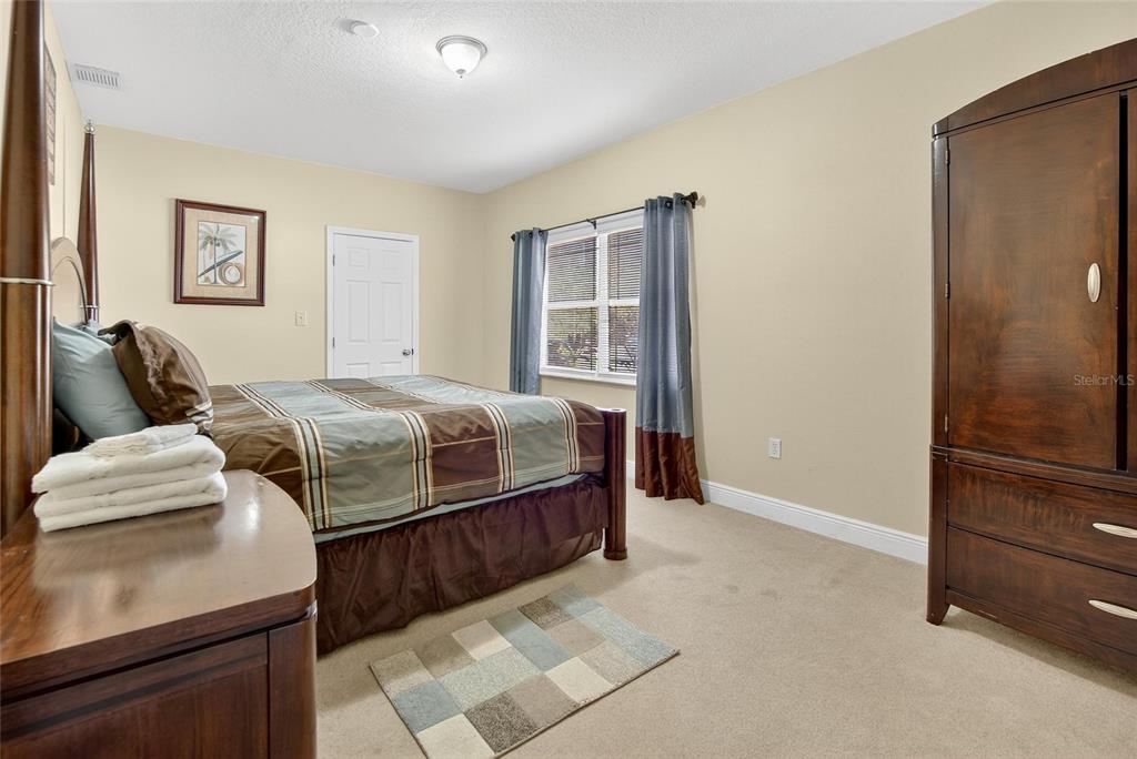 4639 Birdsong Boulevard, Unit 2 Lutz, FL 33559 - Photo 15 of 25 a bedroom with a bed and a dresser