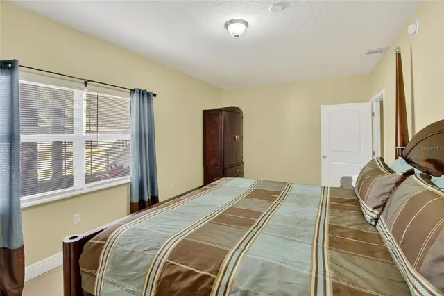 a bedroom with a bed next to a large window