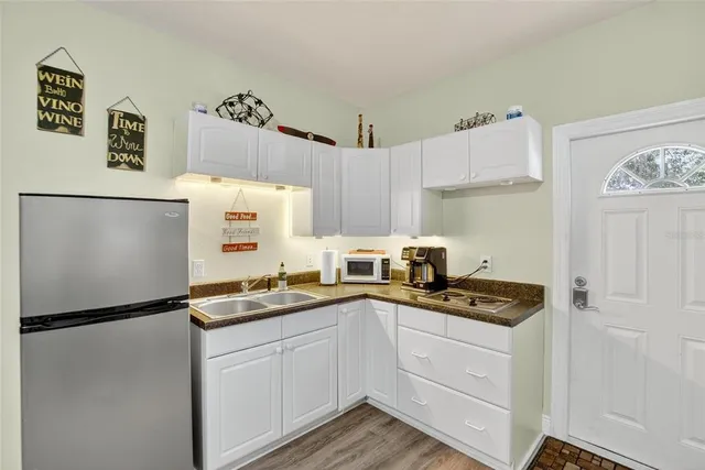 a kitchen with a sink a refrigerator a stove and white cabinets