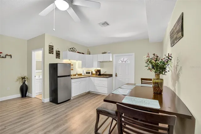 a kitchen with furniture wooden floor and stainless steel appliances