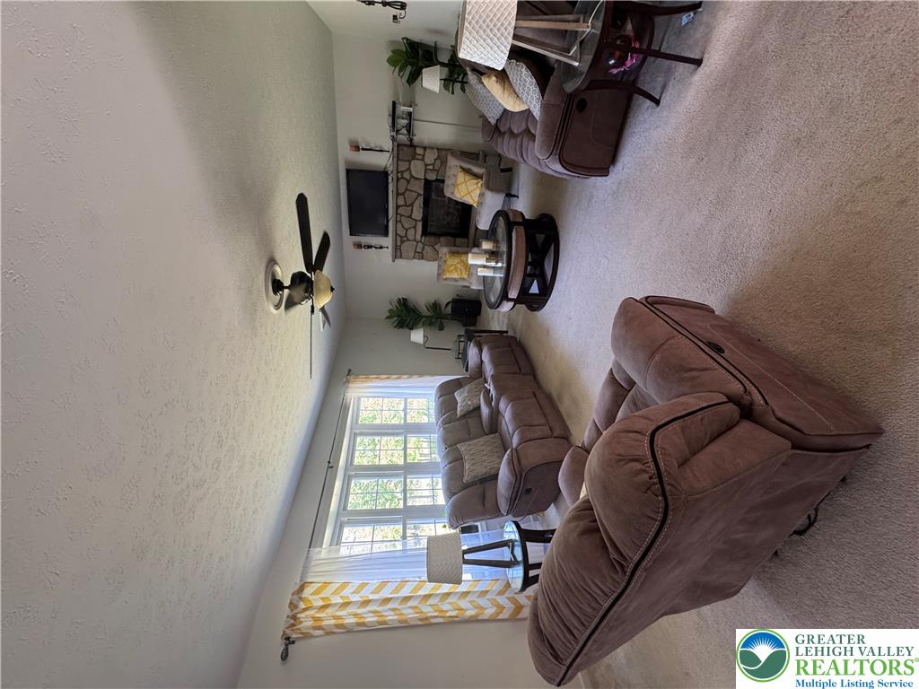 2742 Long Pond Road Long Pond, PA 18334 - Photo 21 of 57 A spacious living room provides a comfortable gathering space with a stone fireplace and a ceiling fan for year-round comfort.