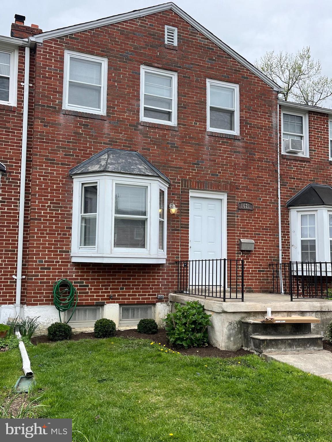 a front view of a house with a garden and yard