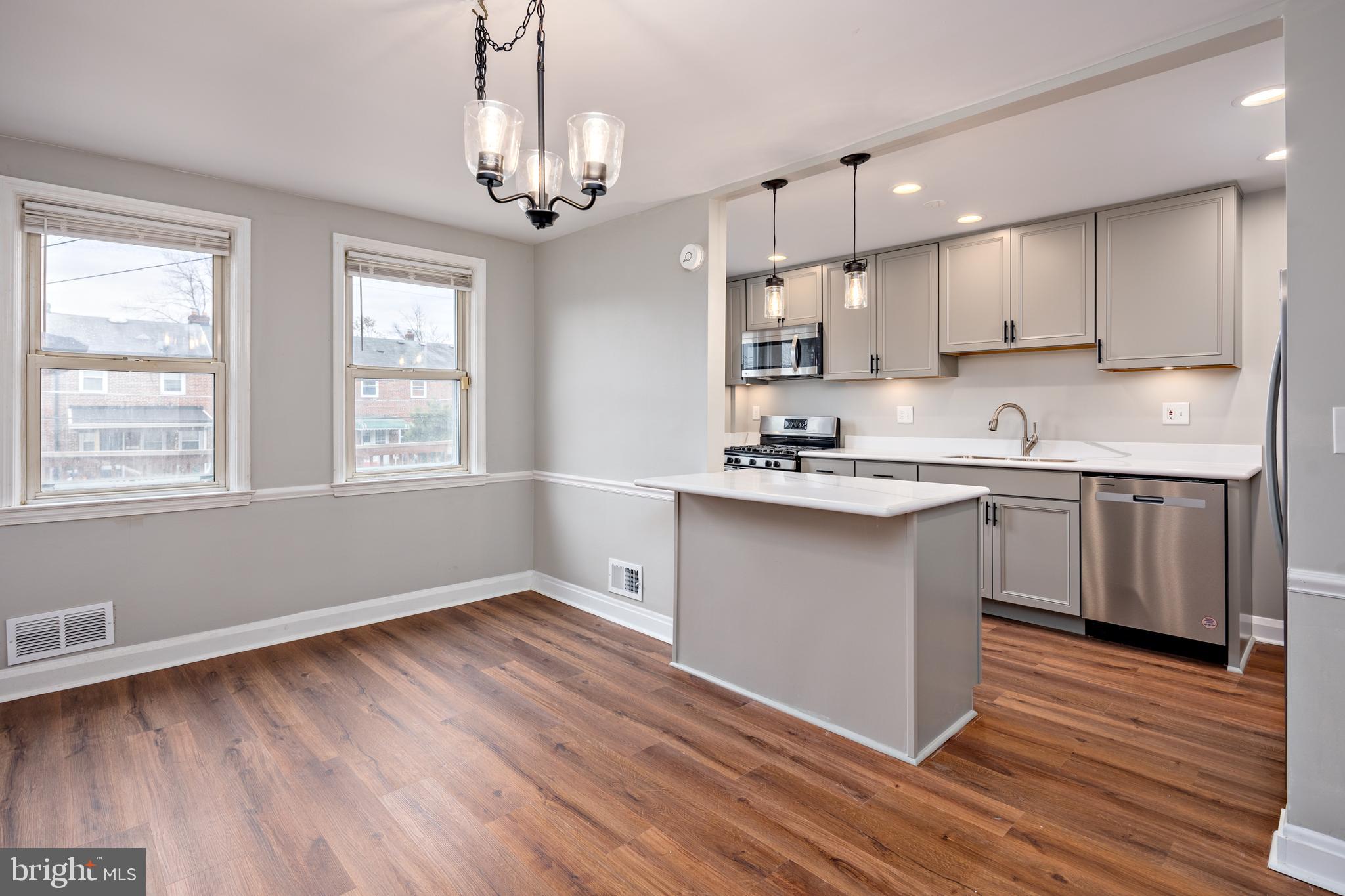 1621 Thetford Road Towson, MD 21286 - Photo 7 of 35 a kitchen with kitchen island granite countertop a sink cabinets and wooden floor