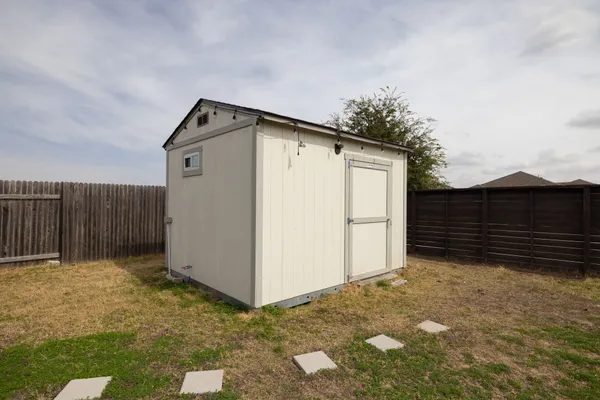 a view of a yard in front of a house with a large tree