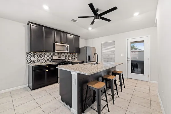 a kitchen with stainless steel appliances granite countertop a refrigerator and a sink