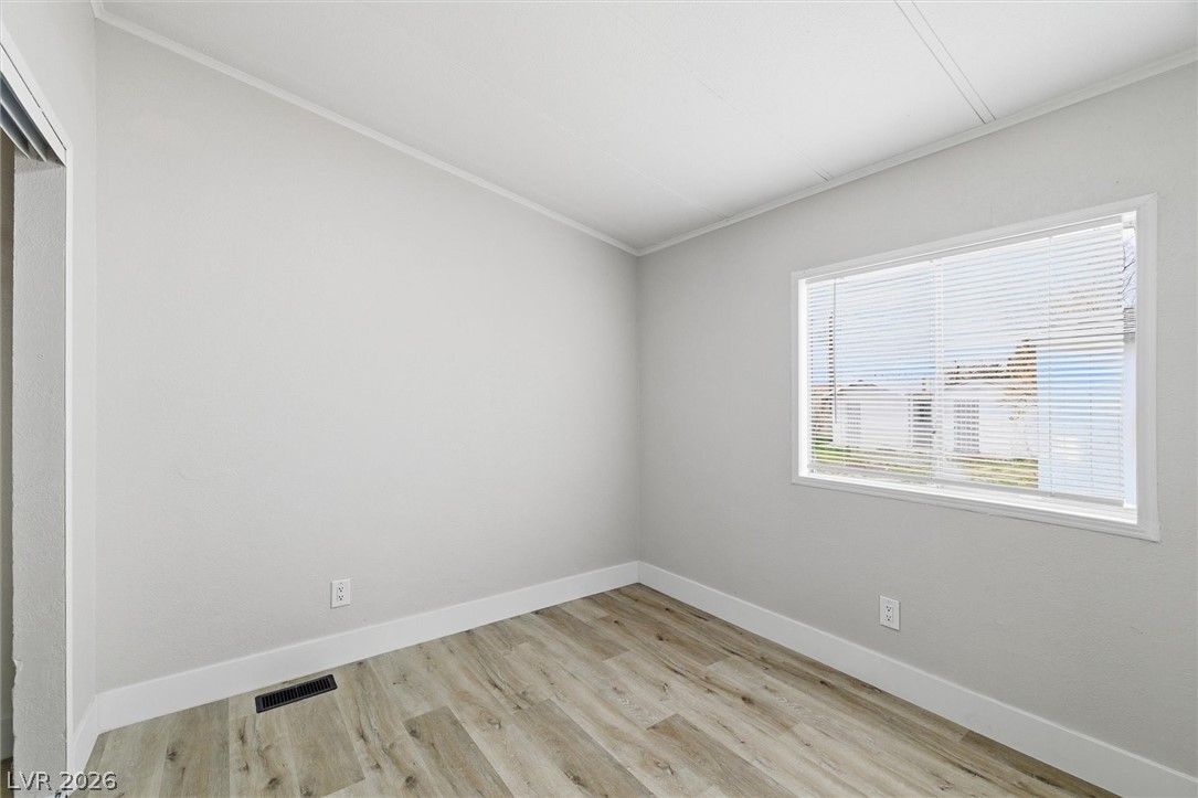 3940 Point Drive Pahrump, NV 89060 - Photo 29 of 35 A well-lit bedroom with modern wood-look flooring provides a clean canvas for personalized living.