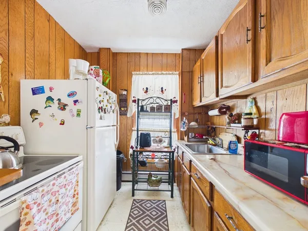 a kitchen with stainless steel appliances granite countertop a refrigerator and a stove top oven