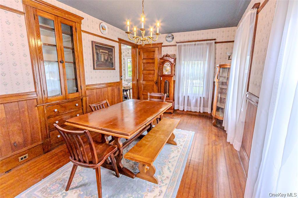 630 New Suffolk Road Cutchogue, NY 11935 - Photo 14 of 33 a dining room with furniture and a chandelier