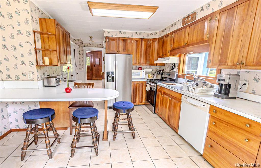 630 New Suffolk Road Cutchogue, NY 11935 - Photo 15 of 33 a kitchen with stainless steel appliances kitchen island granite countertop a sink and cabinets