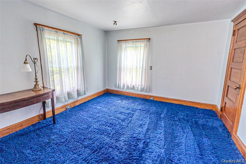 630 New Suffolk Road Cutchogue, NY 11935 - Photo 21 of 33 an empty room with wooden floor and windows