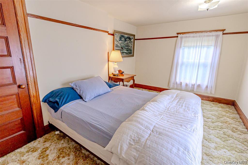 630 New Suffolk Road Cutchogue, NY 11935 - Photo 23 of 33 a bedroom with a bed and a window