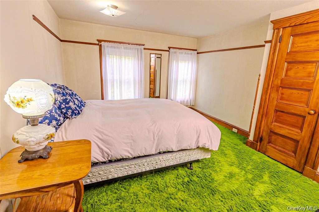 630 New Suffolk Road Cutchogue, NY 11935 - Photo 25 of 33 a bed sitting in a bedroom next to a window