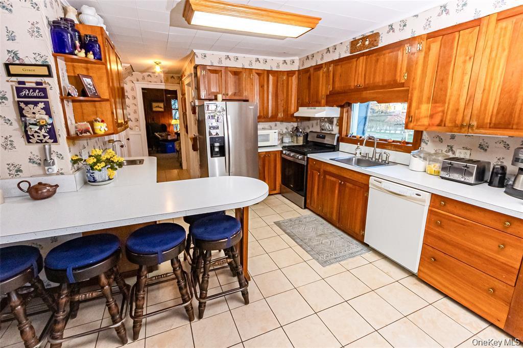 630 New Suffolk Road Cutchogue, NY 11935 - Photo 8 of 33 a kitchen with stainless steel appliances a table chairs and a refrigerator